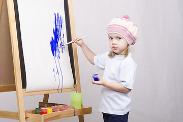 Image showing Girl artist paints on canvas