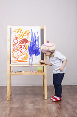 Image showing Girl artist paints on canvas