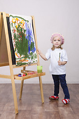 Image showing Girl artist paints on canvas