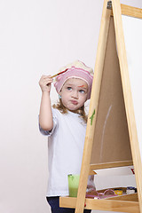 Image showing Girl artist paints on canvas