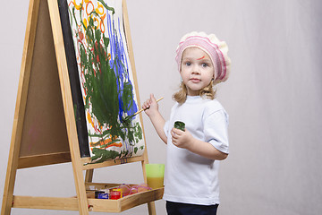 Image showing Girl artist paints on canvas