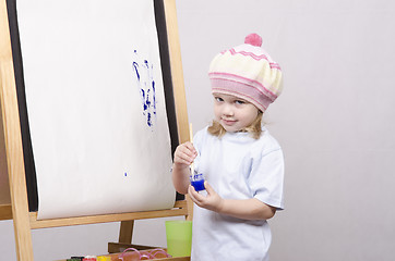 Image showing Girl artist paints on canvas