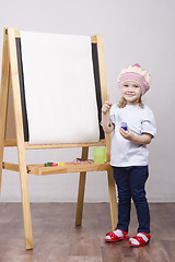 Image showing Girl artist paints on canvas