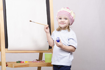 Image showing Girl artist paints on canvas