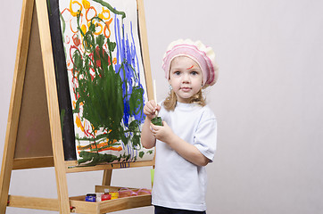 Image showing Girl artist paints on canvas