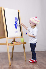 Image showing Girl artist paints on canvas