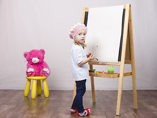 Image showing Girl, the artist draws on easel bear