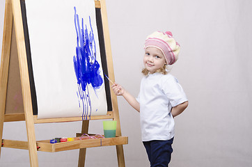 Image showing Girl artist paints on canvas