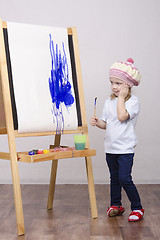 Image showing Girl artist paints on canvas