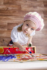 Image showing Girl artist paints on canvas