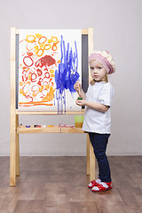 Image showing Girl artist paints on canvas