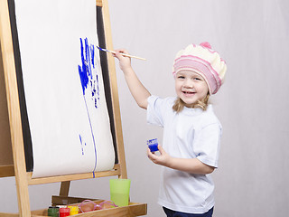 Image showing Girl artist paints on canvas