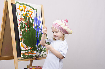 Image showing Girl artist paints on canvas