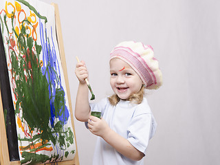 Image showing Girl artist paints on canvas