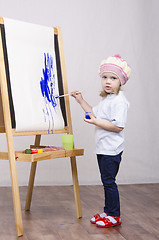 Image showing Girl artist paints on canvas