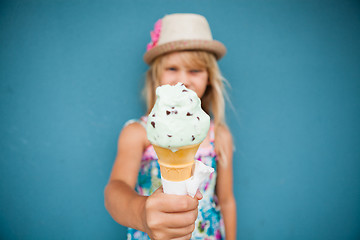 Image showing Ice cream cone held by young girl