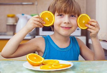 Image showing boy eats orange