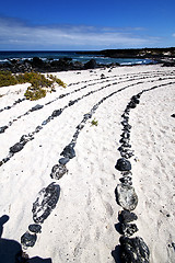 Image showing white  beach  spiral of black rocks in the   lanzarote 