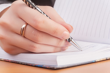 Image showing Woman writing in organizer