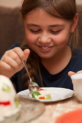 Image showing Little girl eating a cake