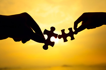 Image showing Silhouette of two hands connect puzzle together 