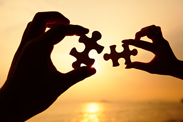 Image showing Man and woman hands trying to connect puzzle pieces 
