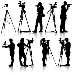 Image showing Cameraman with video camera. Silhouettes on white background. Ve