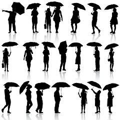 Image showing Set of black silhouettes of men and women with umbrellas. Vector
