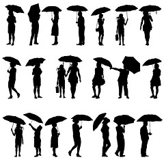 Image showing Set of black silhouettes of men and women with umbrellas. Vector