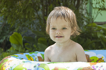 Image showing little girl bathes an inflatable pool in nature