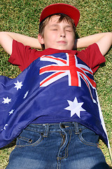 Image showing Patriotic boy with flag draped over him