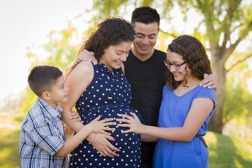 Image showing Hispanic Family Hands on Pregnant Mother Tummy Feeling Baby Kick