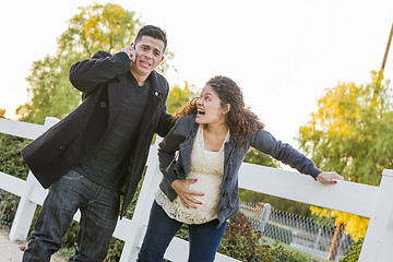 Image showing Pregnant Woman In Pain While Husband Uses Cell Phone Outside