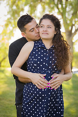 Image showing Hispanic Man Hugs His Pregnant Wife Outdoors At the Park