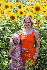 Image showing smiling woman and little girl on sunflowers field