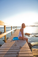 Image showing Attractive woman sitting on pier