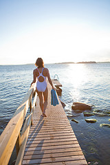Image showing Attractive woman walking on pier