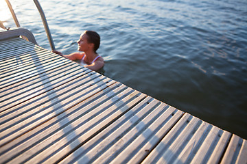 Image showing Edge of pier with woman in water