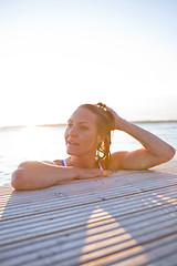 Image showing Attractive woman resting at edge pier