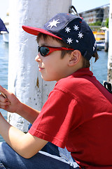 Image showing Child sitting on jetty wharf