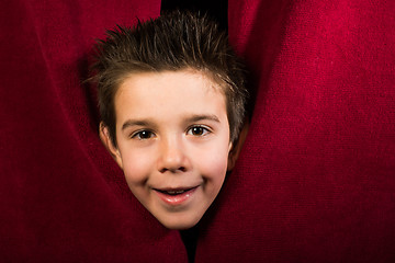 Image showing Child appearing beneath the curtain