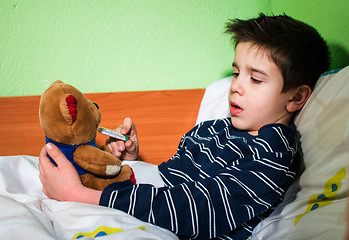 Image showing Sick child in bed with teddy bear