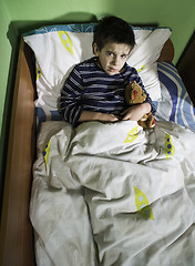 Image showing Sick child in bed with teddy bear