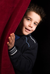 Image showing Child appearing beneath the curtain