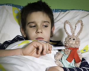 Image showing Sick child in bed with teddy bear