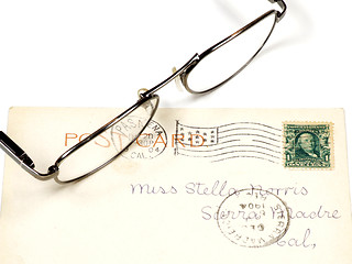 Image showing Antique postcard and eyeglasses