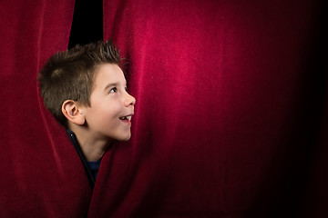 Image showing Child appearing beneath the curtain