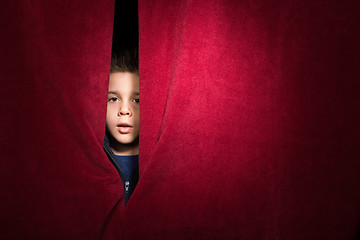 Image showing Child appearing beneath the curtain