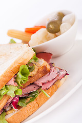 Image showing Delicious pastrami club sandwich and pickles