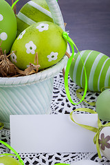 Image showing Colourful green Easter eggs in straw